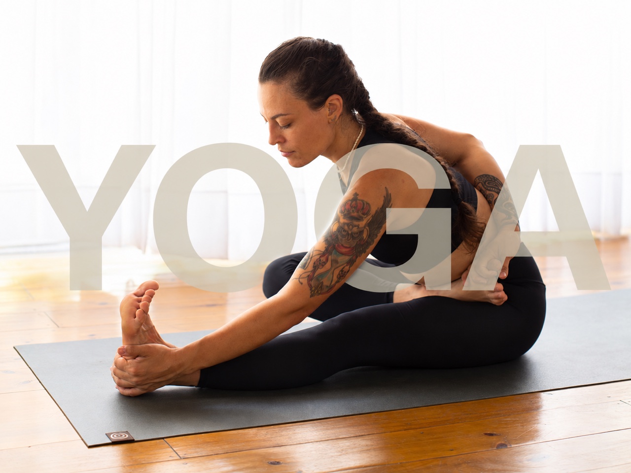 Kety Monteiro praticando Yoga, com a palavra Yoga sobreposta à imagem